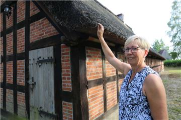 Annette Blohm, Vorsitzende des Heimatvereins Frelsdorf, legt ihre Hand auf das bei Regen oft lange feuchte Reetdach des Heimathauses. Nun kommt eine gute Nachricht von der Gemeinde: Im Jahr 2020 wird definitiv saniert.