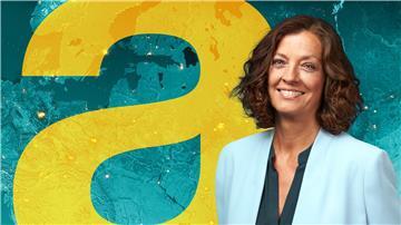 Antje Pieper steht vor einer digitalen Weltkarte im Studio dews „auslandjournals“.