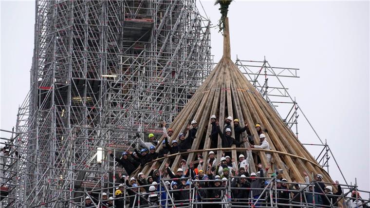 Wiederaufbau von Notre-Dame in Paris Arbeiter feiern den Abschluss des Wiederaufbaus des Dachstuhls der Kathedrale Notre Dame mit einem traditionellen Blumenstrauß.