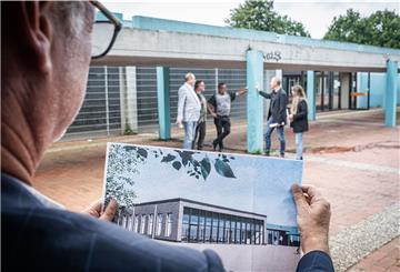 Architekt Andreas Müller zeigt ein Foto der neuen Mensa.