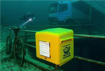 Ein gelber Briefkasten der Marke Eigenbau ist im Kreidesee im Hemmoor in einer Tiefe von 19 Metern unter Normalnull angebracht. 