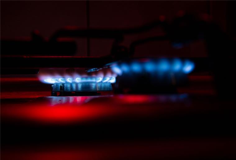 Zwei Gasfelder auf einem Herd werden von rotem Licht angeleuchtet.