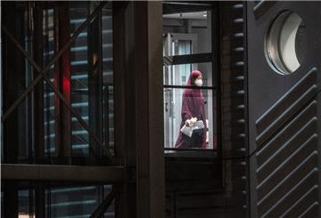 Eine verschleierte Frau mit einer Maske betritt aus der Gangway einer Chartermaschine heraus einen abgeschirmten Bereich der Bundespolizei am Flughafen Frankfurt. 