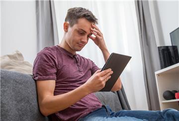 Ein Mann guckt auf ein Tablet. 