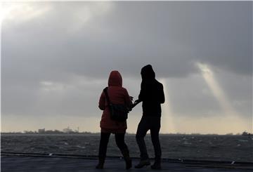 Gegen den starken Wind und die Sturmböen geht dieses junge Paar auf der Seebäderkaje in Bremerhaven.