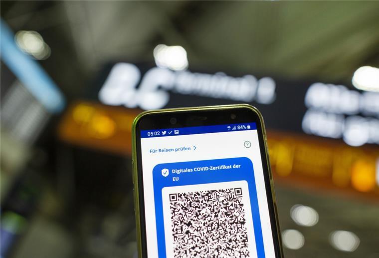 Im Flughafen Köln Bonn Airport ist auf einem Smartphone der QR-Code eines Impfstatus sichtbar.