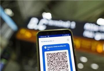 Im Flughafen Köln Bonn Airport ist auf einem Smartphone der QR-Code eines Impfstatus sichtbar.