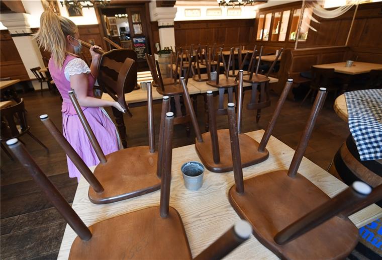 Garmisch-Partenkirchen: Eine Bedienung stellt, in einem Wirtshaus, Stühle auf einen Tisch.
