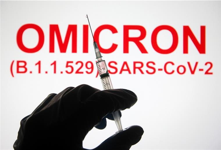 Eine Hand hält vor der Aufschrift «Omicron (B.1.1.529): SARS-CoV-2» eine Spritze hoch. 