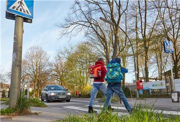 Die Schulkinder Lea (8) und Henry (7) laufen am 16.04.2015 in Hamburg über einen Zebrastreifen auf dem Weg zur Schule.