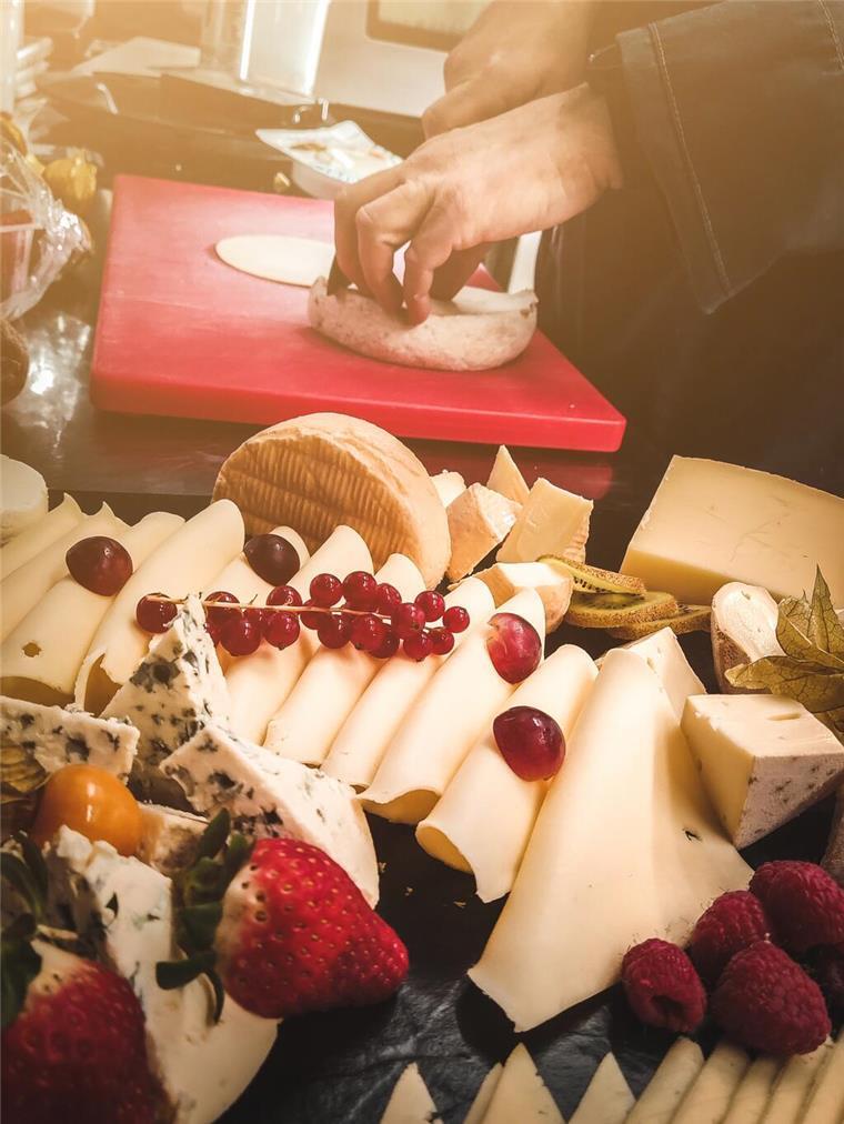Käsevariationen und eine Hand, die Käse schneidet.