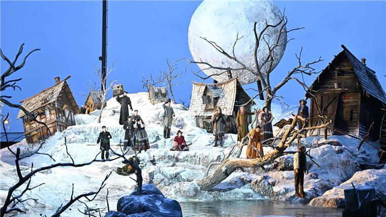 Auf dem Bodensee ist für die Inszenierung ein halb im Wasser versunkenes Dorf entstanden - mit schneebedeckten Hütten, kahlen Bäumen und einem riesigen Mond.