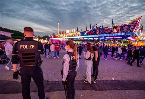 Polizeibeamte stehen auf dem Kirmesgelände Hohen Steinert.