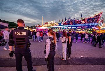 Polizeibeamte stehen auf dem Kirmesgelände Hohen Steinert.