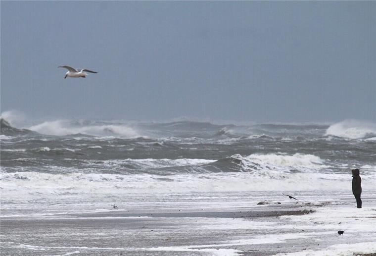 Eine Frau beobachtet die aufgebrachte Nordsee.