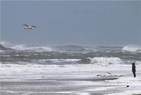 Eine Frau beobachtet die aufgebrachte Nordsee.