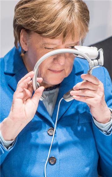 Auf der CeBIT probierte Angela Merkel am Stand von Brother gleich eine Augmented Reality Datenbrille aus.