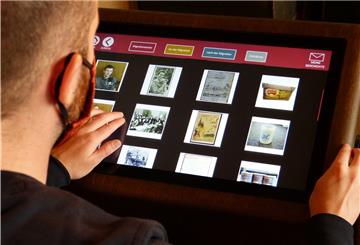 Auf der einen Seite des Biografien-Portals befindet sich ein gläserner Schaukasten, auf der anderen ein Touchscreen-Monitor mit einer dahinterliegenden Datenbank. 