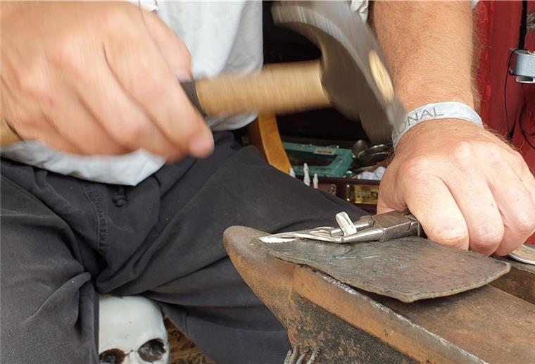 Maritime Tage: Dieses Handwerk habt Ihr noch nicht gesehen Ein Mann hämmert auf ein Stück Silber.