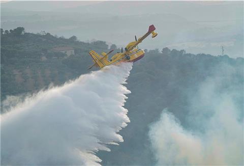 Ein Canadair-Flugzeug wirft Wasser ab, um ein Feuer in der Nähe von Oristano auf der Insel Sardinien zu löschen. 