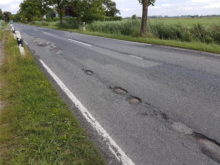 Auf der Landesstraße 121 (Foto) und auf der Kreisstraße 50 sind durch die Umleitung des Verkehrs während der einmonatigen Bauzeit an den Zufahrten zum Wesertunnel Schäden entstanden. Einen Monat danach warten Anlieger und Autofahrer noch auf die Reparatur. 