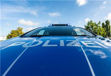 Auf der Motorhaube eines Streifenwagens steht der Schriftzug „Polizei“.