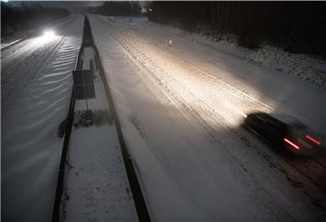 Zwei Autos fahren über die schneebedeckte A2. 