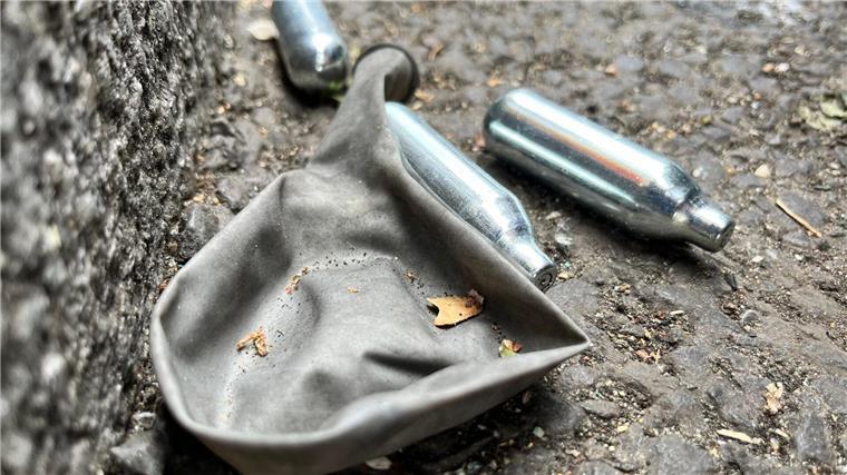 Ärztekammer: Verbot von Lachgas-Verkauf an Minderjährige Auf einer Straße liegen mehrere Gaspatronen und ein Luftballon.
