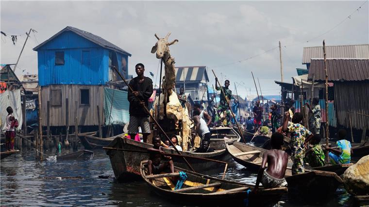 Auf Kanus bewegen sich die Puppenspieler durch Teile der Stadt Lagos im Land Nigeria. 