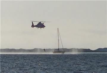 Aufnahme vom Seenotrettungsboot „Fritz Thieme“ aus: Mit dem Hubschrauber wird ein Notfallsanitäter auf dem Segelboot absetzt.