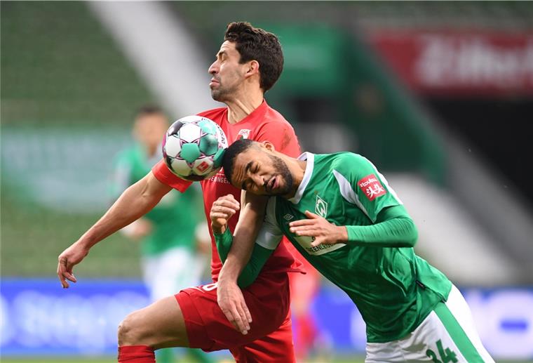 Augen zu und durch: Bremens Jean-Manuel Mbom (rechts) versucht sich gegen Augsburgs Rani Khedira durchzusetzen.