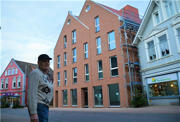 Aus der Bauruine in Bad Bederkesa ist ein stattliches Wohn- und Geschäftshaus geworden. Investor Hans Kieckbusch freut sich, dass es kurz vor Weihnachten noch geklappt hat mit der Enthüllung des einstigen Schandflecks. 