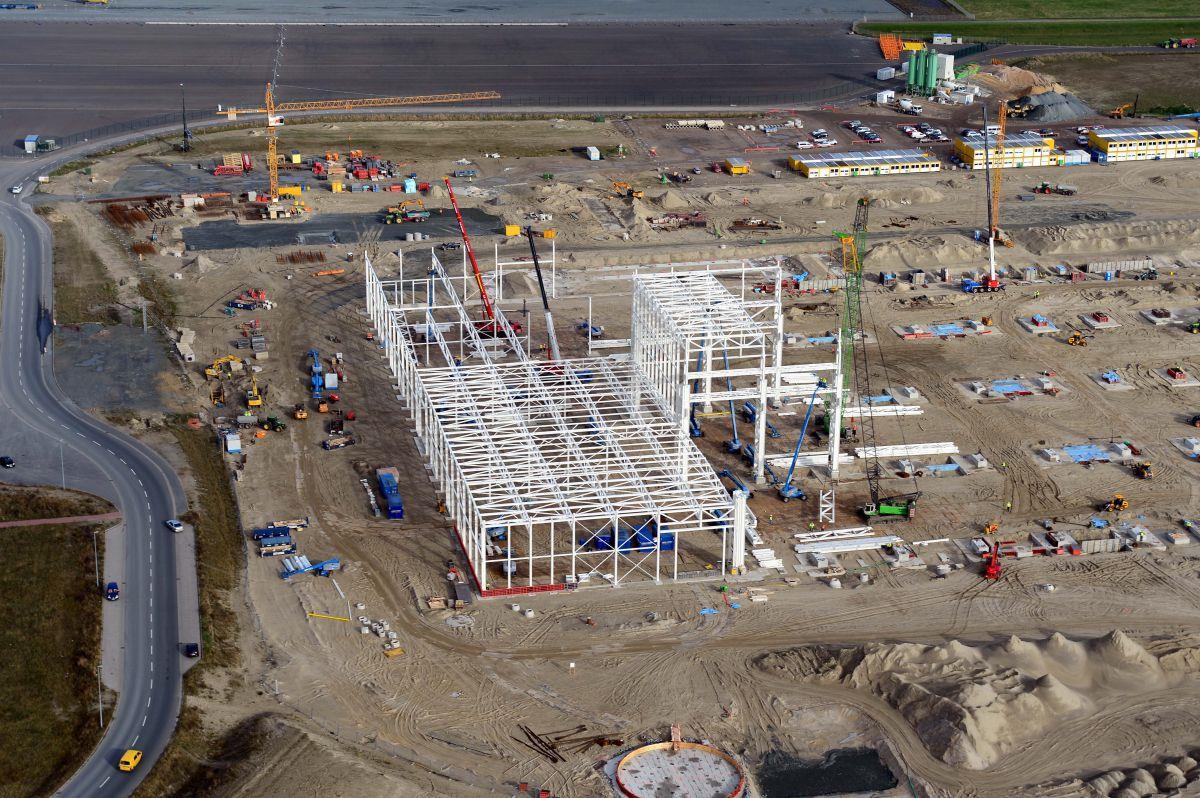 Aus der Vogelperspektive sieht sie aus wie eine riesige Miniatur-Spiellandschaft: Doch gespielt wird in der neuen Siemens-Fabrik zwischen den Cuxhavener Ortsteilen Groden und Altenbruch bestimmt nicht. Das Stahlgerüst der Nebenhalle, das einmal Wände und Dach tragen wird, nimmt bereits Formen an. Bis Januar soll auch die 320 Meter lange und 160 Meter breite Hauptproduktionshalle fertig sein. 