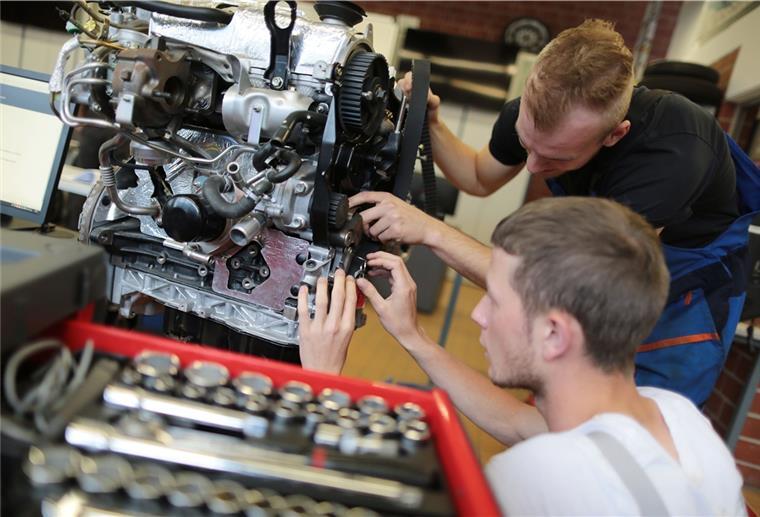 Ende des Verbrennungsmotors trifft die Werkstätten Auszubildende zum KFZ-Mechatroniker arbeiten an einem Motor. Nicht nur die Ausbildung wird sich durch das Aus für Verbrennungsmotoren grundlegend ändern.