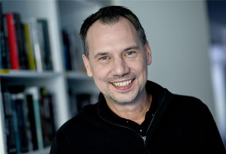 Kreuzfahrt-Thriller auf der Mein Schiff 4 Autor Sebastian Fitzek vor einem Bücherregal.