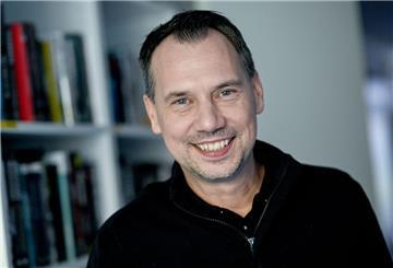 Autor Sebastian Fitzek vor einem Bücherregal.