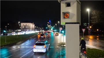 Autos fahren an einem Radargerät vorbei, der Autofahrer fotografiert, die trotz roter Ampel auf eine Kreuzung fahren.