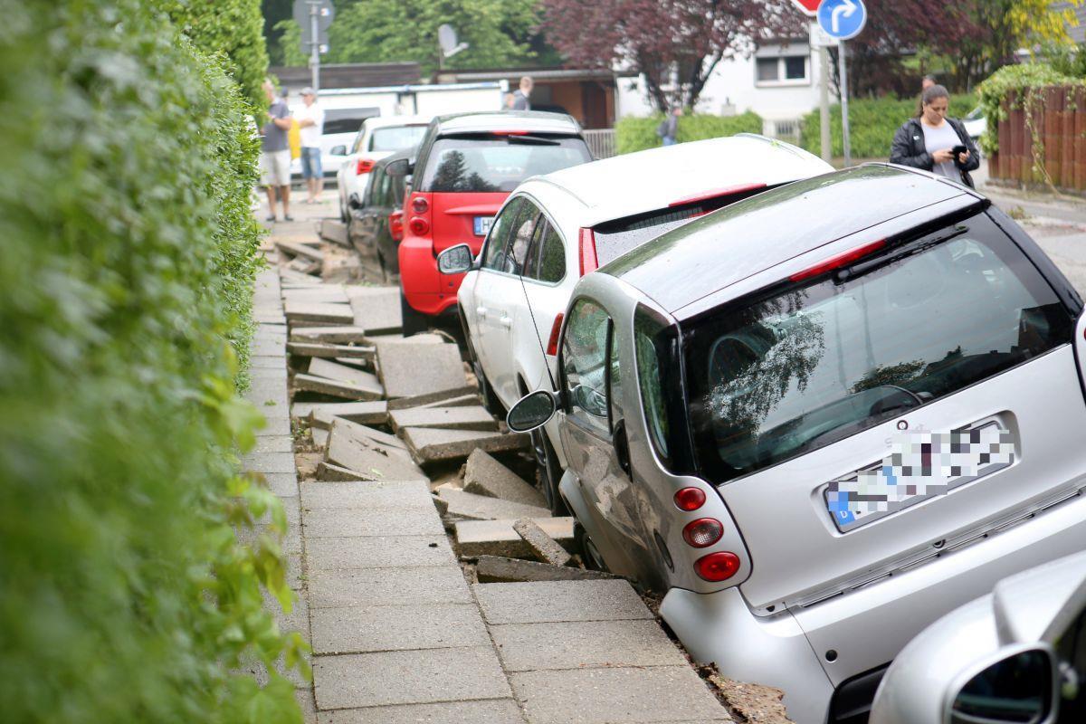 Nach dem heftigen Starkregen im Norden: Die Aufräumarbeiten beginnen Autos stehen nach einem Unwetter an einer unterspülten Straße in Hamburg-Bergedorf.