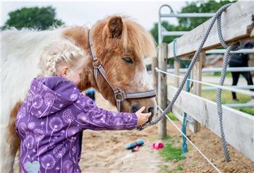 Ayline streichelt auf einem Hof in Norddeutschland das Shetlandpony "Schulzi". 