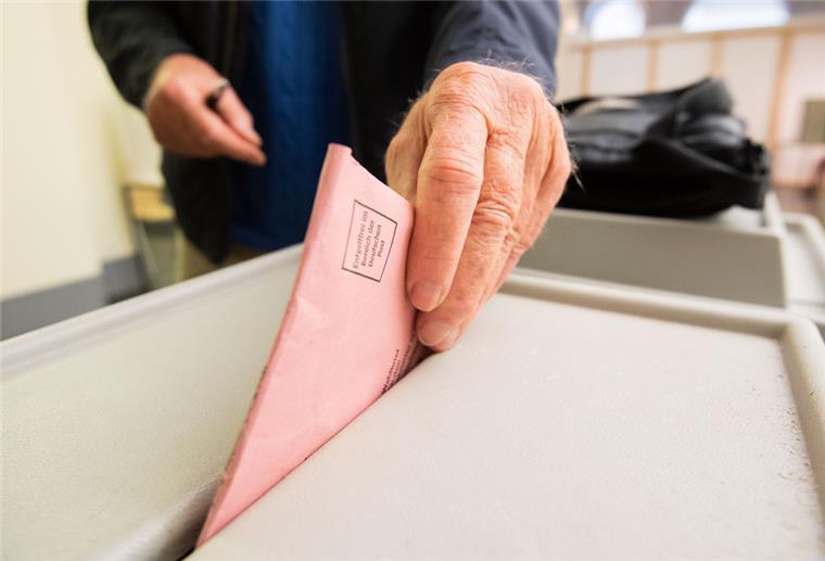 Ein Mann wirft seinen Stimmzettel für die Bundestagswahl in eine Urne im Neuen Rathaus.