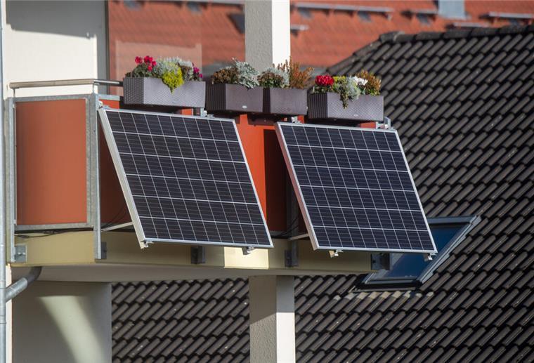 Solarmodule für ein sogenanntes Balkonkraftwerk hängen an einem Balkon.