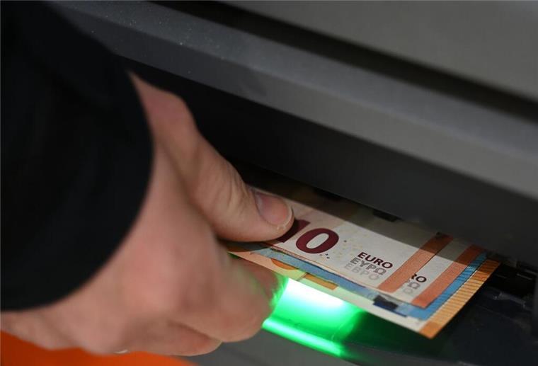 Beliebter Service plötzlich weg! Millionen Kunden verlieren Bargeld-Zugang Ein Mann zieht Geldscheine aus dem Ausgabefach eines Geldautomaten. Bankkunden der Cash-Group gucken ab Juni in die Röhre: Sie können an weniger Punkten Bargeld abheben.