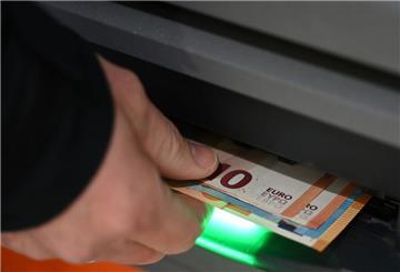 Ein Mann zieht Geldscheine aus dem Ausgabefach eines Geldautomaten. Bankkunden der Cash-Group gucken ab Juni in die Röhre: Sie können an weniger Punkten Bargeld abheben.