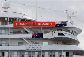 Banners hängen von der „Artania“, nachdem sie am Samstag, 28. März, in Fremantle, Australien, anlegen durfte. Wann sie wieder nach Bremerhaven kommt, ist derzeit unklar.