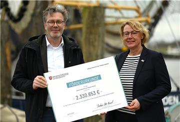 Barbara Otte-Kinast (CDU), Niedersachsens Landwirtschaftsministerin, und Gerd Kraus, Leiter des Bremerhavener Thünen-Instituts für Seefischerei, zeigen im Hafen von Greetsiel die Förderurkunde über rund 2,3 Millionen Euro. Mit einem Forschungsprojekt sollen Chancen für eine stärkere regionale Wertschöpfung der Krabbenfischerei in Norddeutschland ausgelotet werden. 