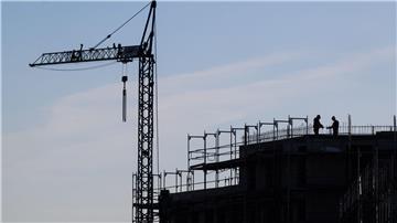 Bauarbeiter stehen auf der Baustelle eines Mehrfamilienhauses.