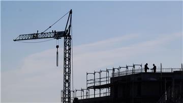 Bauarbeiter stehen auf der Baustelle eines Mehrfamilienhauses.
