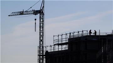 Bauarbeiter stehen auf der Baustelle eines Mehrfamilienhauses.