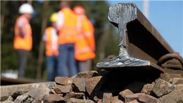 Bauarbeiter stehen auf einer Baustelle am Bahnknoten Dessau-Roßlau.