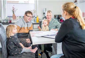 Bauherrenberaterin Elvira Dreier (rechts) zeigt Yvonne und Marvin Holst mit ihren Kindern Fiete und Lotta den Grundrissplan ihres Hauses in Dorum. Foto: Hartmann
